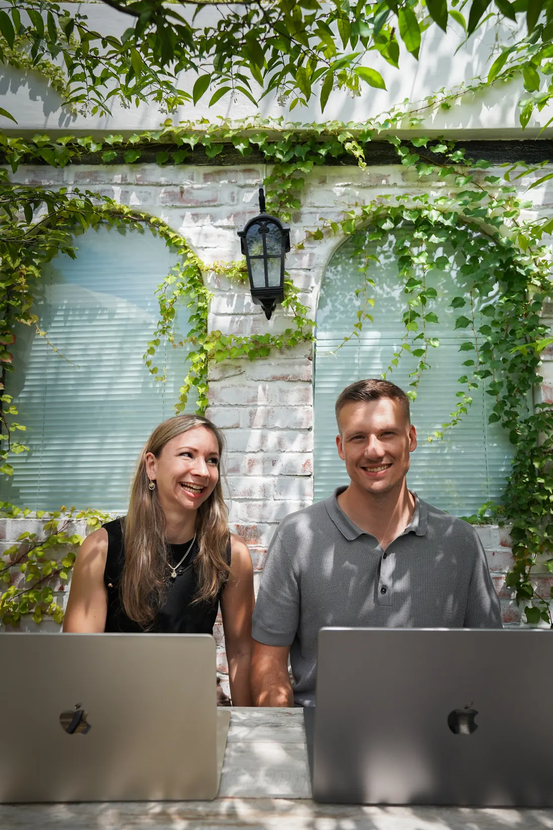 Sophie und Tobias lachen gemeinsam am Laptop